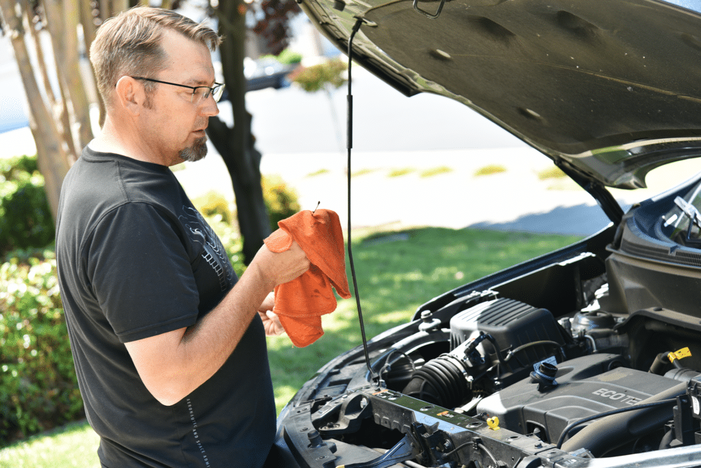 A man works on the engine of his vehicle.