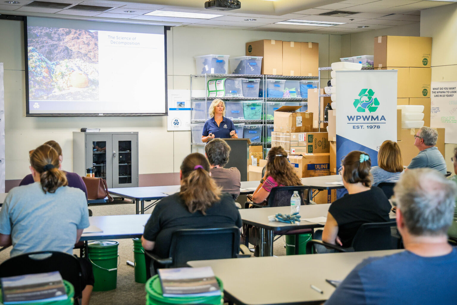Woman presents a PowerPoint slide on the Science of Decomposition to a classroom of attendees at Compost Workshop